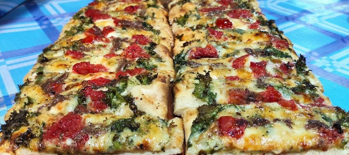 Focaccia messinese: un classico della tradizione messinese con tuma, pomodori e scarola